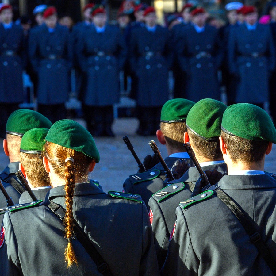 Feierliches Gelöbnis der Bundeswehr auf einem Markplatz mit Soldaten und Soldatinnen der Ehrenformation. Im Hintergrund sind Rekruten und Rekrutinnen der Bundeswehr zu sehen. © dpa Foto: Klaus-Dietmar Gabbert