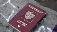 Ein junger Russe zeigt seinen Pass nach der Einreise in Finnland. © picture alliance Foto:  Antti Aimo-Koivisto