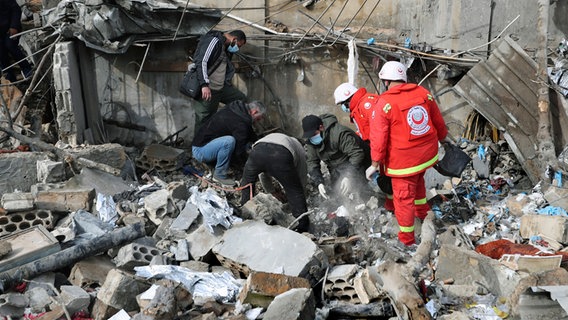 Sanitäter suchen nach Opfern in den Trümmern eines Sanitätszentrums, das durch einen israelischen Luftangriff im Dorf Hebbariye im Südlibanon zerstört wurde. © AP Foto: Mohammad Zaatari