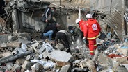 Sanitäter suchen nach Opfern in den Trümmern eines Sanitätszentrums, das durch einen israelischen Luftangriff im Dorf Hebbariye im Südlibanon zerstört wurde. © AP Foto: Mohammad Zaatari