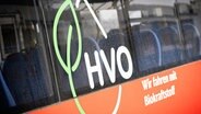 Auf einem Bus steht in großen Buchstaben "HVO", der Bus wird mit dem neuen Biokraftstoff betankt. © picture alliance Foto: Moritz Frankenberg