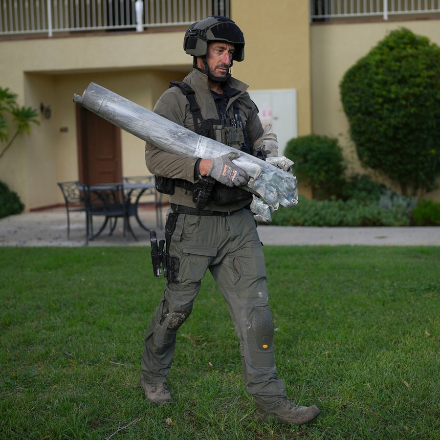 Ein israelischer Bombenentschärfer trägt die Überreste einer Rakete, die angeblich aus dem Libanon auf den Kibbuz Kfar Blum abgefeuert wurde. © AP Foto: Ohad Zwigenberg