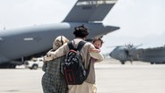Eine Familie auf dem Flughafen von Kabul bei der Rettungsaktion. © picture alliance Foto: Sgt. Samuel Ruiz