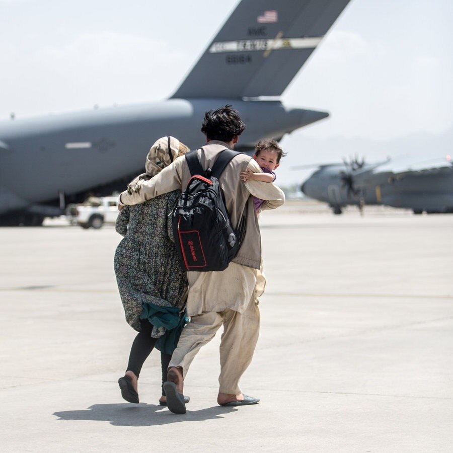 Eine Familie auf dem Flughafen von Kabul bei der Rettungsaktion. © picture alliance Foto: Sgt. Samuel Ruiz