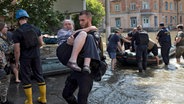 Bewohner werden aus einem überfluteten Viertel evakuiert, nachdem der Kachowka-Damm (Ukraine) gesprengt wurde. © AP/dpa Foto: Roman Hrytsyna