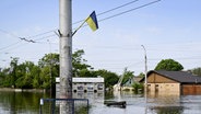 Eine Straße ist überschwemmt. Der Stausee des Dnipro im Süden der Ukraine hat nach der Zerstörung des Kachowka-Staudamms laut Behördenangaben inzwischen mehr als ein Drittel des im Frühjahr angesammelten Hochwassers verloren. © picture alliance/dpa/Lehtikuva Foto: Antti Aimo-Koivisto