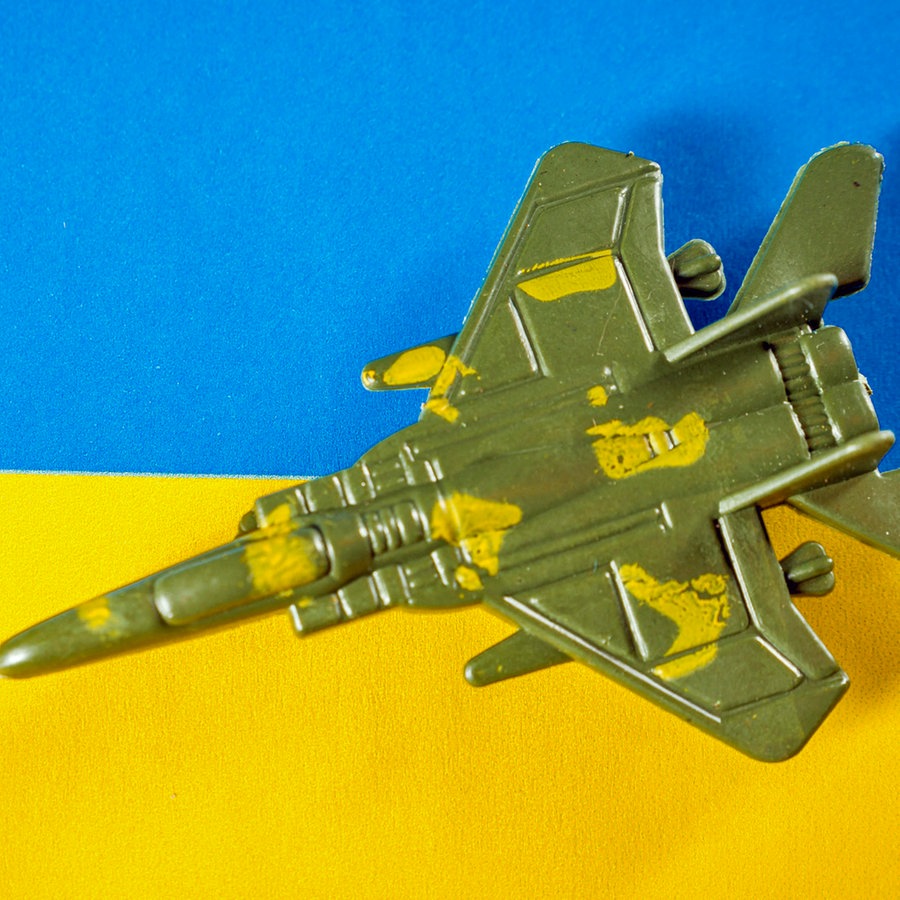 Ein Kampfjet auf einer Landesflagge der Ukraine (Symbolbild). © CHROMORANGE Foto: Michael Bihlmayer