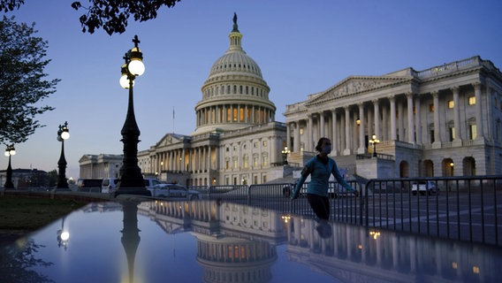 Eine Frau joggt abends am Kapitol in Washington (USA) vorbei. © AP/dpa Foto: J. Scott Applewhite