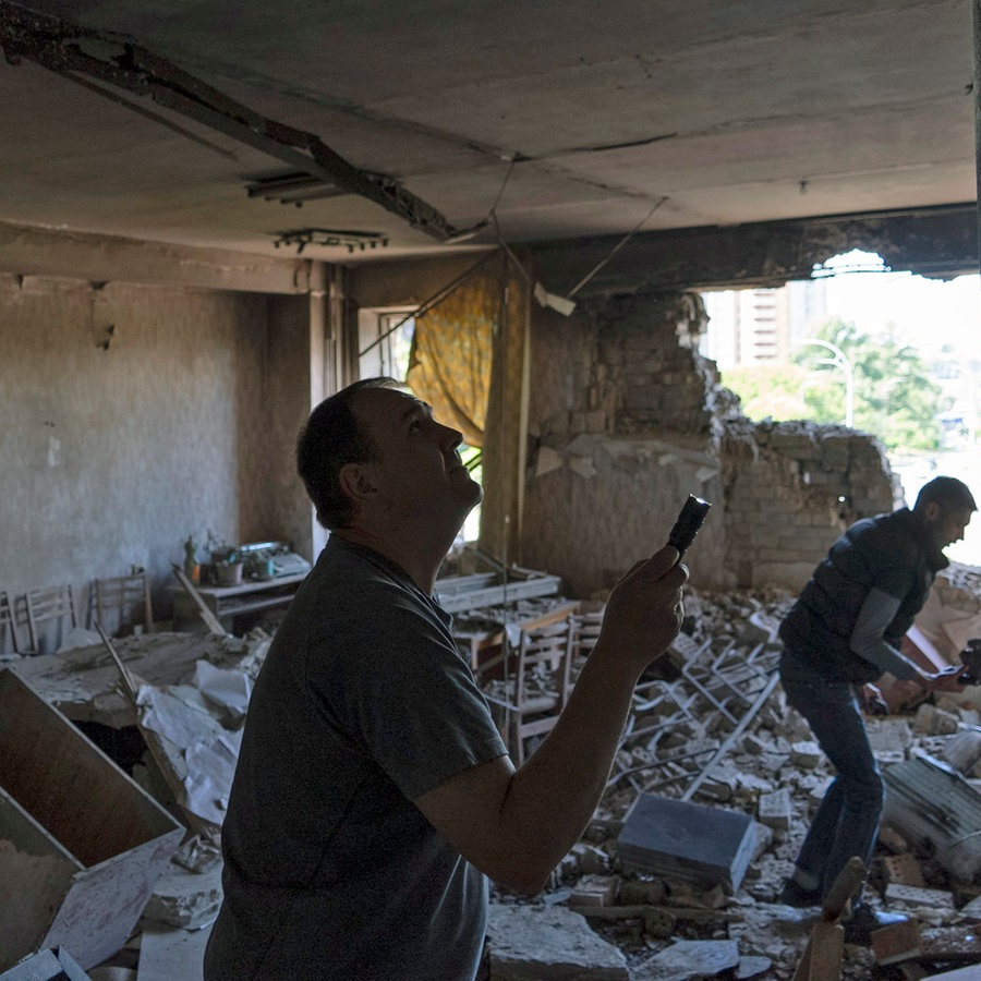 Männer inspizieren ihr Büro in Kiew (Ukraine), das bei einem nächtlichen Angriff von Russland durch eine Drohne beschädigt wurde. © AP/dpa Foto: Vasilisa Stepanenko