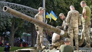 Soldaten bereiten eine Ausstellung mit erbeuteten russischen Panzern auf einer Straße in Kiew vor. © Uncredited/kyodo/dpa 