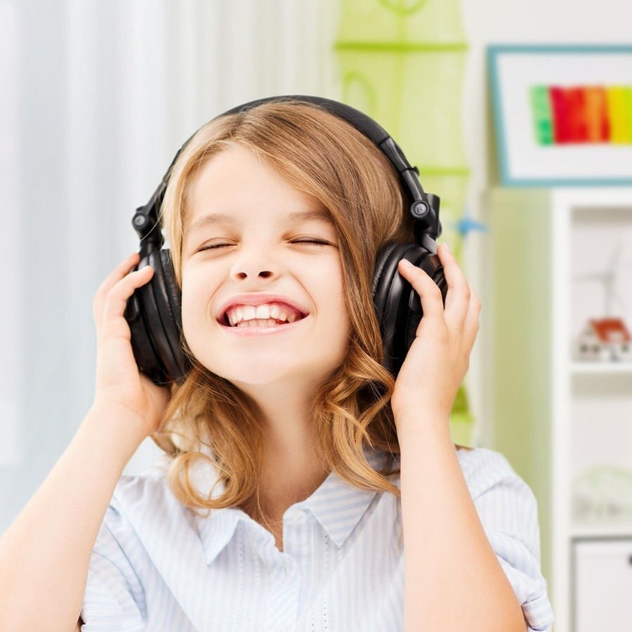 Ein lachendes Kind mit Kopfhörern auf den Ohren © picture alliance / Zoonar | lev dolgachov Foto: lev dolgachov