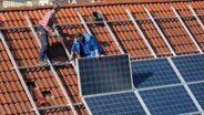 Arbeiter installieren Solarzellen auf einem Dach © picture alliance / Daniel Kalker | Daniel Kalker Foto: picture alliance / Daniel Kalker | Daniel Kalker