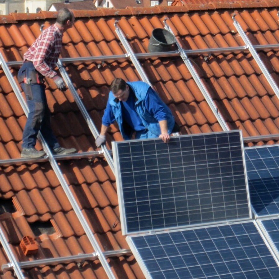 Arbeiter installieren Solarzellen auf einem Dach © picture alliance / Daniel Kalker | Daniel Kalker Foto: picture alliance / Daniel Kalker | Daniel Kalker