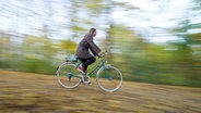 Eine Frau auf einem Fahrrad © picture alliance / dpa Themendienst | Tobias Hase Foto: Tobias Hase