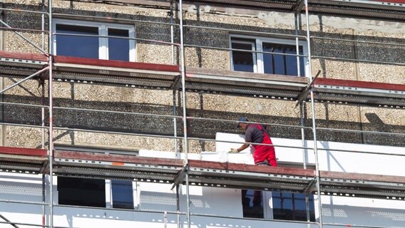 Die Fassade eines in plattenbauweise errichteten Wohnhauses wird gedämmt. © dpa picture alliance Foto: Jens Wolf