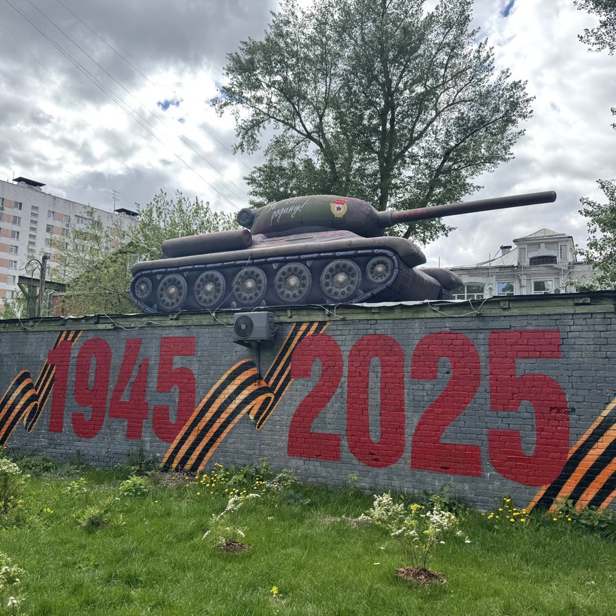 An einer Mauer, auf der zum Weltkriegsgedenken eine Panzer-Attrappe platziert wurde, steht zu lesen "80 (Jahre) Sieg 1945 2025". Die Moskauer Stadtverwaltung hat die Attrappe im Stadtbezirk Basmanny installiert - zum Gedenken an das Weltkriegsende vor 80 Jahren. © picture alliance/dpa | Andre Ballin Foto: Andre Ballin