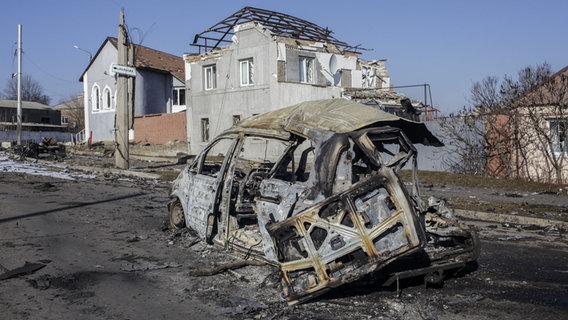 Ein zerstörtes Auto steht vor einem durch einen russischen Angriff zerstörtem Haus © APicture alliance / AA Foto: Marek M. Berezowski