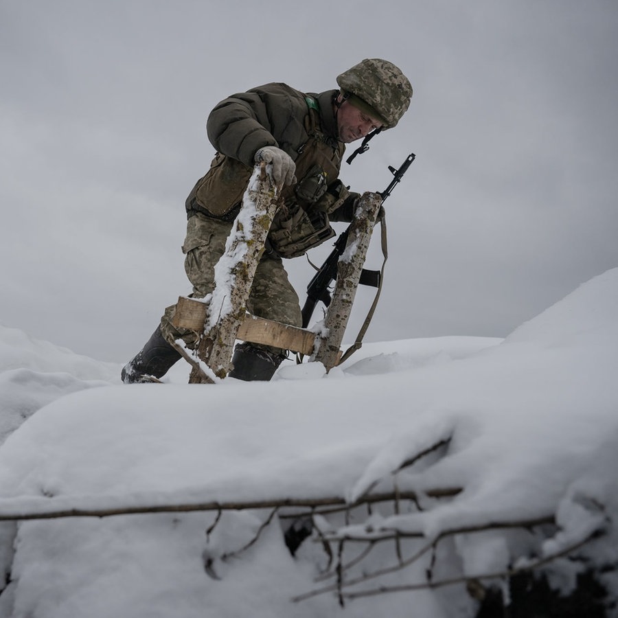Ein ukrainischer Soldat läuft durch Schnee an der Front in Kupiansk in der Region Donezk am 21. November © picture alliance Foto: Ozge Elif Kizil