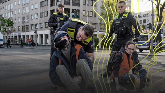 Zwei Aktivist:innen der Letzten Generation, eine noch festgeklebt am Asphalt, der andere wird von einem Polizisten hochgehoben. © picture alliance Foto: Vladimir Menck