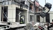 Mitarbeiter des russischen Katastrophenschutzministeriums arbeiten an der Seite einer eingestürzten Bäckerei nach einem Angriff ukrainischer Truppen in Lyssjansk (Region Luhansk, Ostukraine). © Uncredited/Russian Emergency Ministry Press Service/AP/dpa 