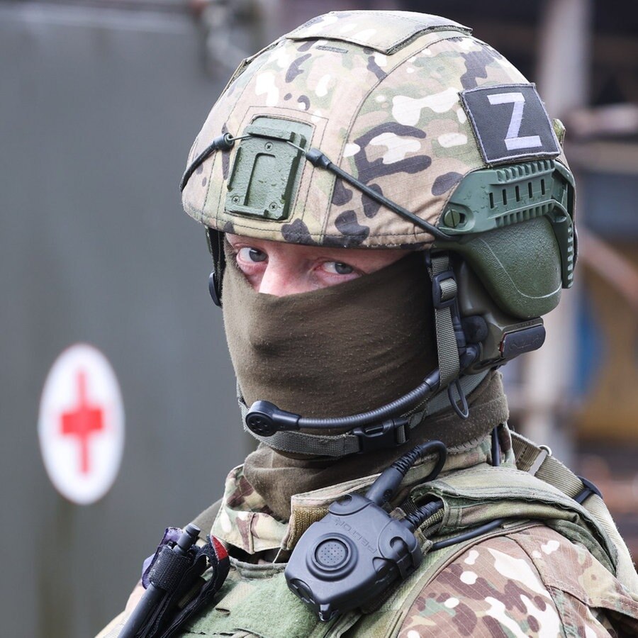 Ein russischer Soldat on Mariupol steht vor einem Wagen des Internationalen Roten Kreuz. © picture alliance Foto: Vladimir Gerdo