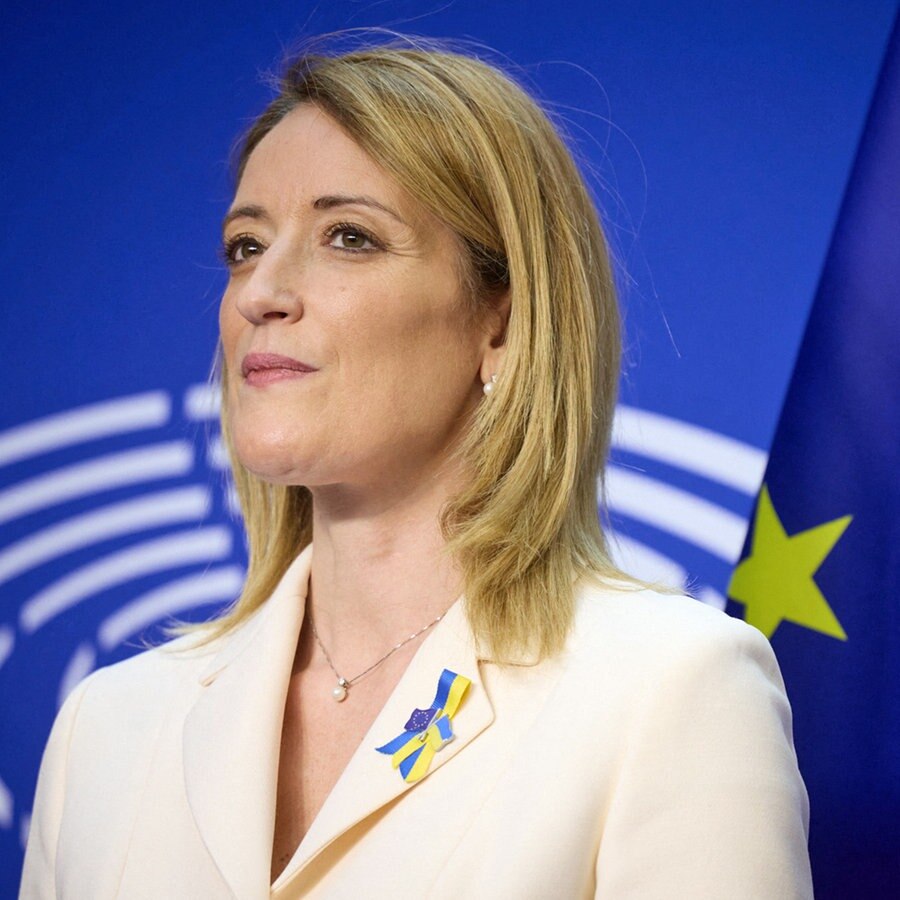 Ein Porträtbild zeigt die Präsidentin des Europäischen Parlaments, Roberta Metsola, mit EU-Fahne und Parlamentslogo im Hintergrund. © abaca Foto: ABACA
