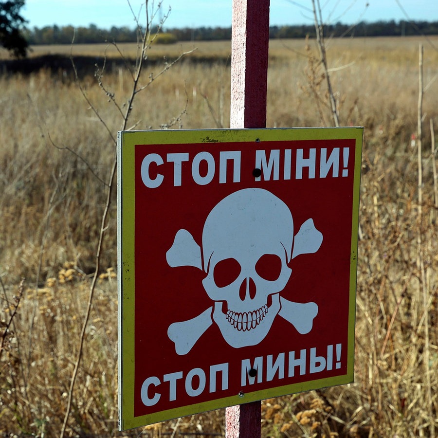 Ein Warnschild "Stop! Minen" ist in dem Bereich zu sehen, in dem die Entminung mit Hilfe modernster Technik durchgeführt wurde in der Region Charkiw (Ukraine). © Ukrinform/dpa 