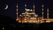 Blick auf die Mondsichel hinter einer Moschee. © picture alliance / Anadolu | Ali Atmaca Foto: Ali Atmaca