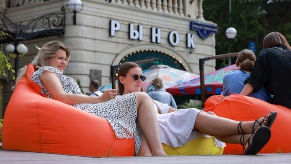 Zwei Frauen sitzen in Relaxstuhlen in einem Viertel von Moskau © picture alliance/dpa/TASS Foto: Vladimir Gerdo