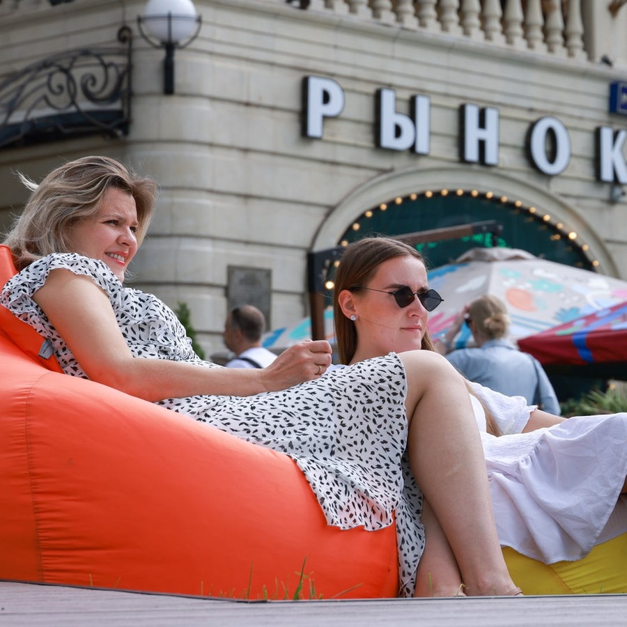 Zwei Frauen sitzen in Relaxstuhlen in einem Viertel von Moskau © picture alliance/dpa/TASS Foto: Vladimir Gerdo