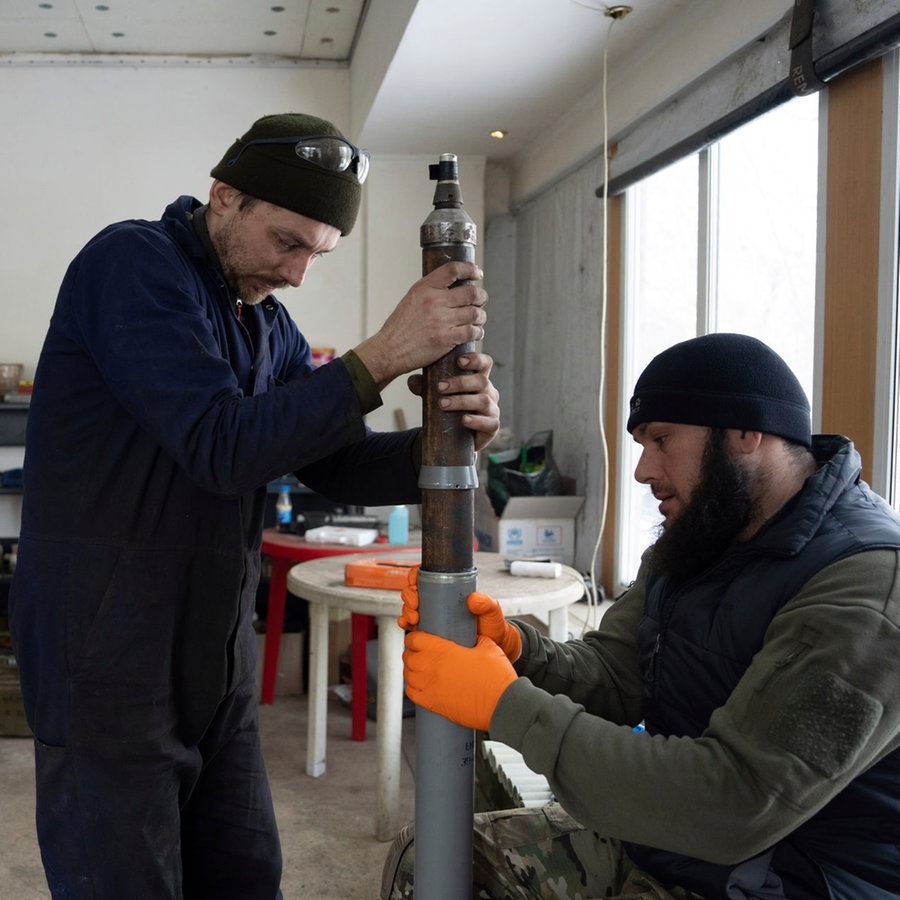 Ukrainische Soldaten bereiten
selbstgebaute Raketen an der Frontlinie vor © picture alliance Foto: Evgeniy Maloletka