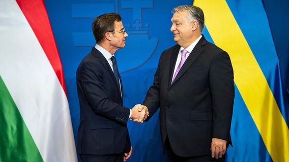 Der schwedische Ministerpräsident Ulf Kristersson (links) und der ungarische Ministerpräsident Viktor Orban (rechts) geben sich in Budapest die Hand. © dpa Foto: Marton Monus
