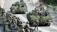 Bundeswehrsoldaten überqueren während des Nato-Manövers "Iron Wolf 2017" über eine Pontonbrücke den Fluß Neris mit ihren Panzern. © dpa/AP Foto: Mindaugas Kulbis