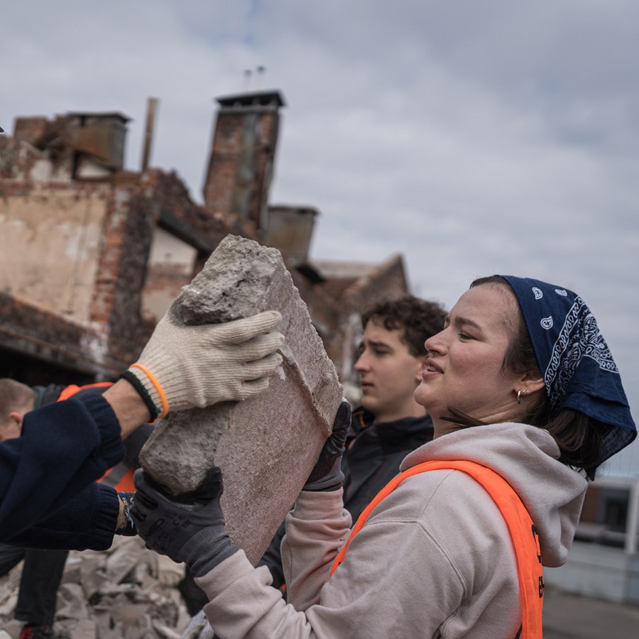 Zwei Helfer der NGO Brave to Rebuild helfen beim Wiederaufbau eines zerstörten Hauses in der Ukraine. © picture alliance Foto: Adri Salido