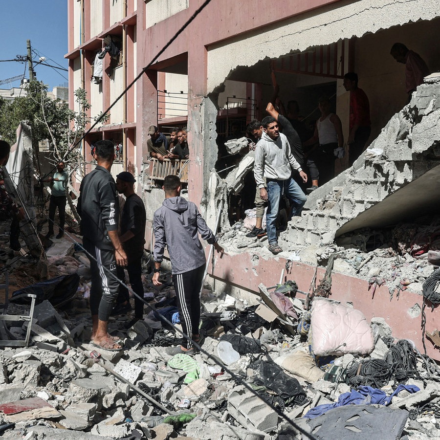 Menschen begutachten die Shuhada-Schule in Nuseirat (Gazastreifen), die von einem israelischen Luftangriff getroffen wurde. © APA Images via ZUMA Press Wire/dpa Foto: Omar Ashtawy Apaimages