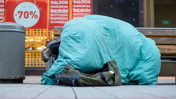 Eine Person schläft auf einer Bank. © picture alliance/dpa Foto: Philipp Schulze