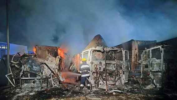 Feuerwehrleute arbeiten daran, ein Feuer an einem Ort des russischen Angriffs in der Nähe des Seehafens in Odessa (Ukraine) zu löschen. © Uncredited/Odesa Region Administration/AP/dpa 