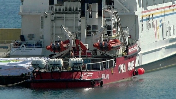 Das Schiff der spanischen Hilfsorganisation "Open Arms" liegt neben einem Fährschiff im Hafen von Larnaca (Zypern). © Uncredited/AP/dpa 