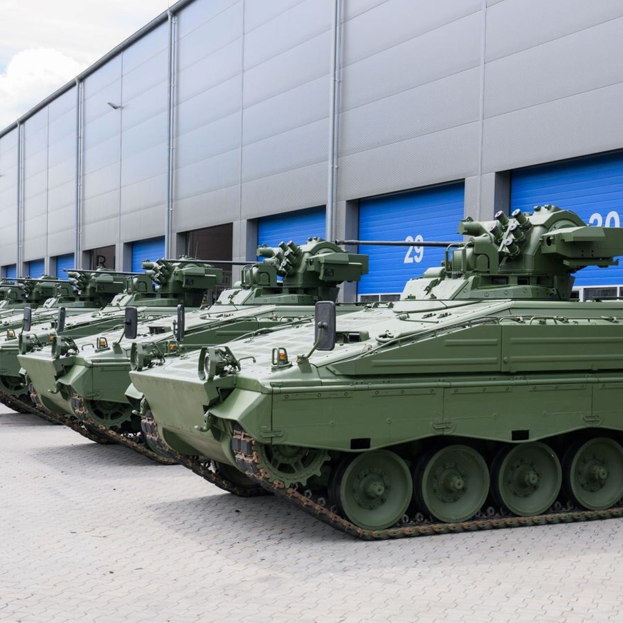 Wieder aufbereitete Marder-Schützenpanzer stehen bei einer Führung durch das Rheinmetall-Werk anlässlich der Sommerreise des niedersächsischen Wirtschaftsministers vor einer Halle. © picture alliance/dpa Foto: Julian Stratenschulte