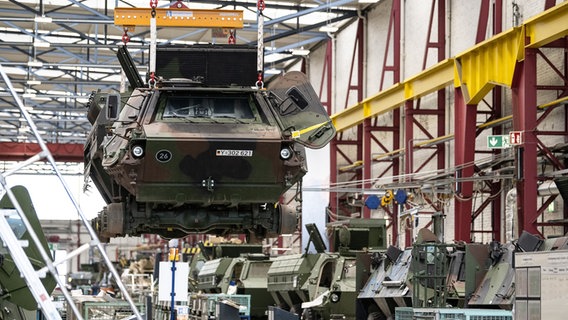Ein Panzer vom Typ Fuchs schwebt in der Fertigungshalle von Rheinmetall © picture alliance Foto: Swen Pförtner