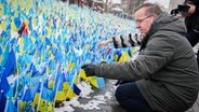 Boris Pistorius (SPD), Bundesminister der Verteidigung, schaut sich in Kiew ein Meer ukrainischer Fahnen auf den Maidan an. © picture alliance Foto: Kay Nietfeld