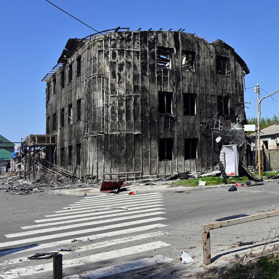 Anwohner gehen an beschädigten Gebäuden im Zentrum von Pokrowsk vorbei, dem Schauplatz der schwersten Gefechte mit den russischen Truppen in der Region Donezk (Ukraine). © AP/dpa Foto: Michael Shtekel