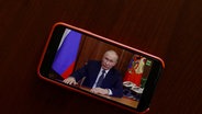 Auf einem Handy wird die Fernsehansprache von Wladimir Putin zur Mobilmachung gezeigt. © picture alliance Foto: Sefa Karacan