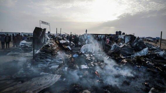 Palästinenser betrachten die Zerstörung nach einem israelischen Luftangriff auf ein Flüchtlingslager in Rafah. © AP Foto: Jehad Alshrafi