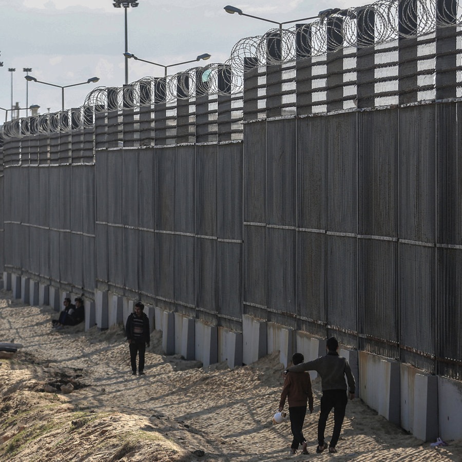 Palästinenser stehen an der Grenze zwischen dem Gazastreifen und Ägypten nahe Rafah. © AP Foto: Mohammed Talatene