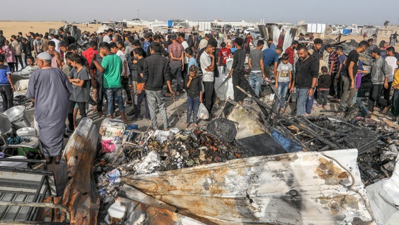 Palästinenser betrachten die Zerstörung nach einem israelischen Luftangriff auf ein Flüchtlingslager in Rafah. © dpa Foto: Abed Rahim Khatib