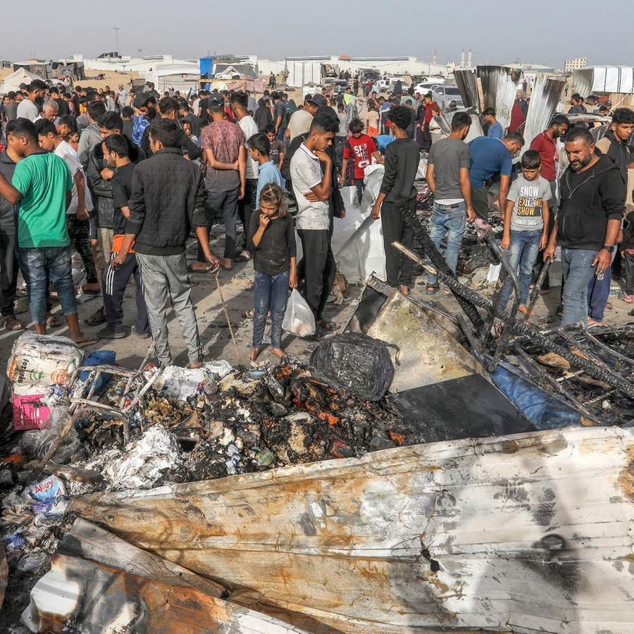 Palästinenser betrachten die Zerstörung nach einem israelischen Luftangriff auf ein Flüchtlingslager in Rafah. © dpa Foto: Abed Rahim Khatib