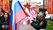 Russische Kadetten halten Fahnen am Start der Autorallye "Hero Cities - Cities of Heroes" im Vorfeld der Feierlichkeiten zum 80. Jahrestag des Sieges über Nazi-Deutschland im Zweiten Weltkrieg in Moskau. © dpa/TASS Foto: Mikhail Tereshchenko