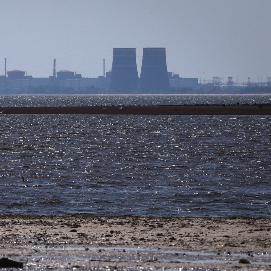 Das Kernkraftwerk Saporischschja ist im Hintergrund des flachen Kachowka-Stausees nach der Zerstörung des Kachowka-Staudamms zu sehen. © picture alliance/dpa/AP Foto: Kateryna Klochko