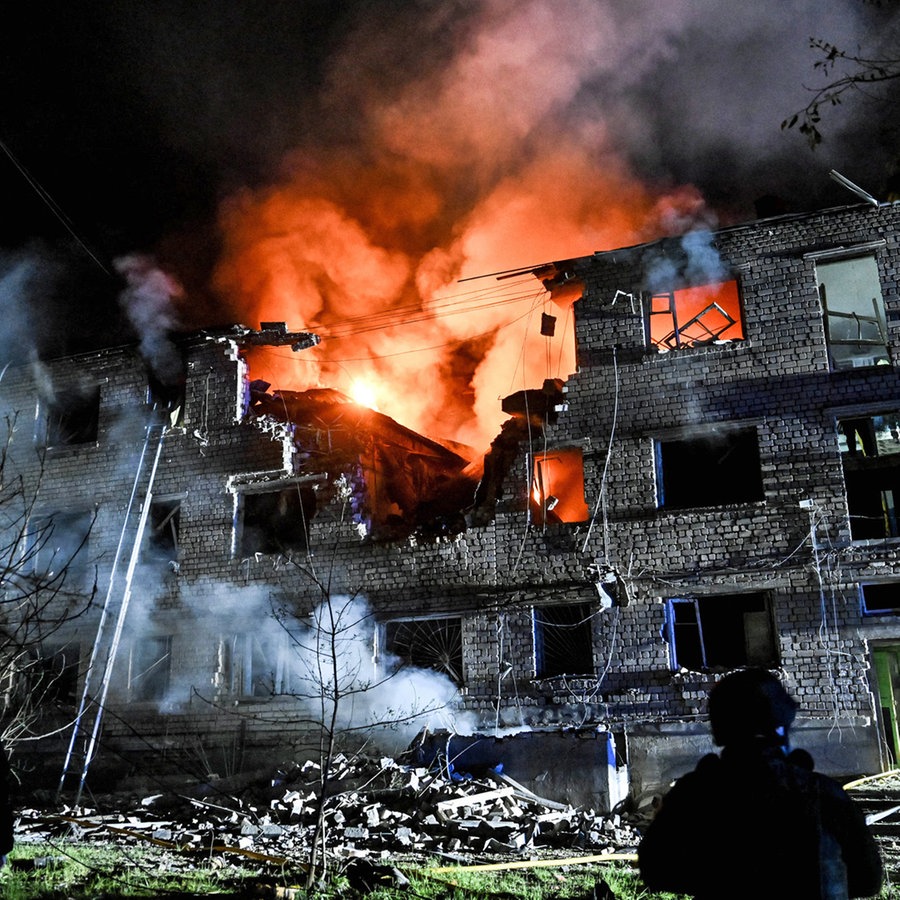 Feuerwehrleute arbeiten in einem Wohnblock in Saporischschja (Ukraine), der durch einen russischen Drohnenangriff beschädigt wurde. © Ukrinform/dpa Foto: Dmytro Smolienko